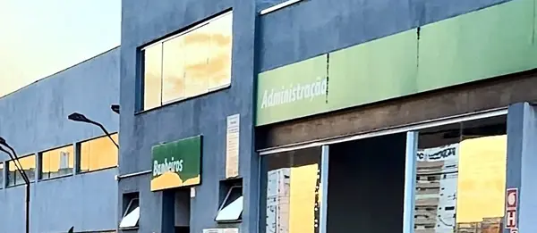 Prédio da administração e dos banheiros do complexo no fim de tarde, com a luz dourada refletida nas janelas